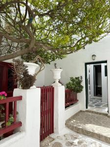 une maison blanche avec une clôture rouge et un arbre dans l'établissement LaLaLand, à Mykonos