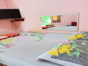 Schlafzimmer mit einem Bett, einem Fenster und einem Spiegel in der Unterkunft OYO 75489 Leelawadee NonPho Resort (Amnatcharoen) in Amnat Charoen