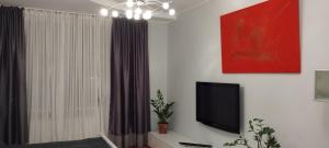 uma sala de estar com uma televisão de ecrã plano na parede em AveSol Apartment em Riga