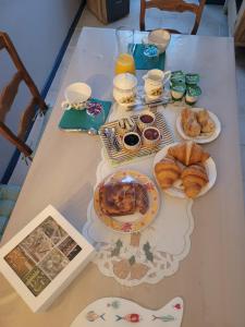 a table with plates of pastries and orange juice at Chambre chez l'habitant in Aubigny-sur-Nère