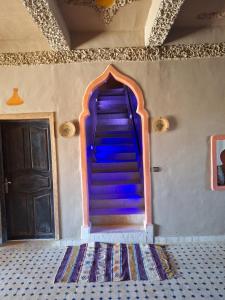 una rampa di scale in una stanza con porta di Riad Merzouga Dunes a Merzouga