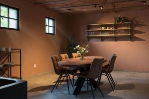 a dining room with a wooden table and chairs at Cuypershof in Oosterzele