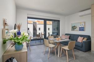 a living room with a couch and a table and chairs at Apartments Irena in Cavtat