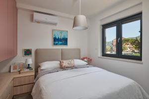 a bedroom with a large bed and a window at Apartments Irena in Cavtat +36 photos