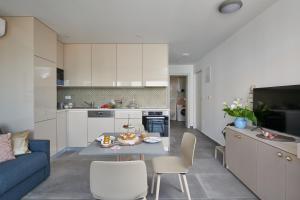 a kitchen and living room with a table and a couch at Apartments Irena in Cavtat