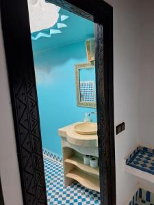 y baño con lavabo y espejo. en Riad Merzouga Dunes, en Merzouga
