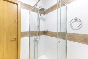 a shower with a glass door in a bathroom at Los Naranjo in Villamanrique de Tajo +26 photos