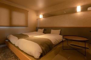a bedroom with a large bed and a table at Matsumoto Tourist Hotel in Matsumoto