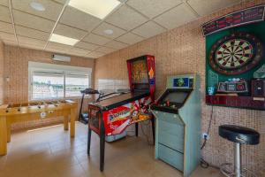 a room with a pinball machine and a dart board at Los Montero in Villamanrique de Tajo