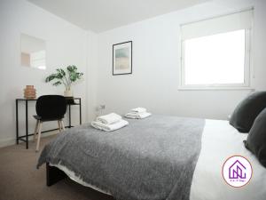um quarto com uma cama com uma cadeira e uma janela em Victoria Wharf, Stunning Cardiff Bay Apartment em Cardiff