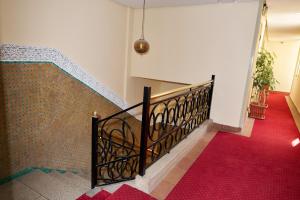 a staircase with a black railing and a red carpet at Hotel Bab Mansour in Meknès