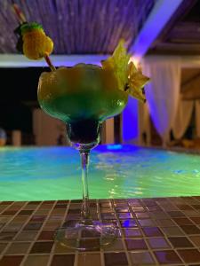un vaso de martini con una flor en una mesa en Haber Hotel & SPA en Matemwe