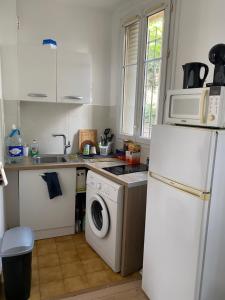 a kitchen with a washing machine and a refrigerator at Superbe appartement aux portes de Paris avec terrasse in Le Kremlin-Bicêtre