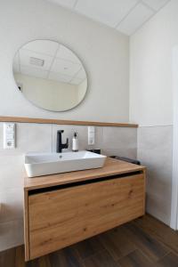 a bathroom with a sink and a mirror at Ammerhuus Boardinghomes in Edewecht