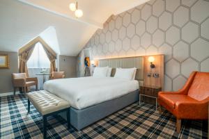 una habitación de hotel con una cama grande y una silla en The Queen at Chester Hotel, BW Premier Collection en Chester