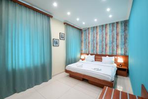 a bedroom with a large bed with blue curtains at Mia Casa Hotel Yerevan in Yerevan