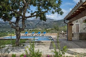 una piscina con sillas, una mesa y un árbol en Villa Sestadors en Selva