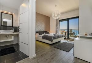 een slaapkamer met een bed en een badkamer met een wastafel bij Villa Nani in Podstrana