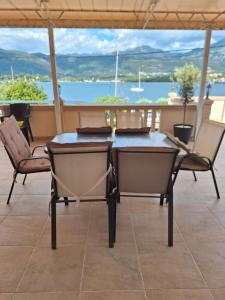 stół i krzesła na patio z widokiem na wodę w obiekcie Apartments Klakor PS w mieście Tivat