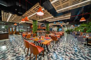 um restaurante com mesas, cadeiras e plantas em Park Regis Business Bay em Dubai