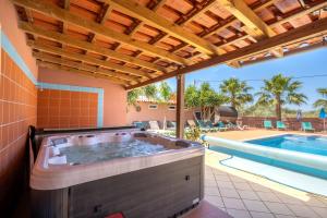 een hot tub in een huis met een zwembad bij Villa Paradis - Quartos in Pêra