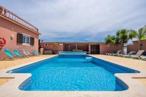 uma piscina com cadeiras e uma casa em Villa Paradis - Quartos em Pêra