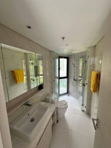 y baño con lavabo, aseo y ducha. en Cassia apartment, en Laguna Phuket