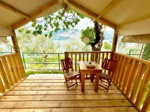 a wooden porch with a table and chairs on it at Camping Monja in Brenzone sul Garda