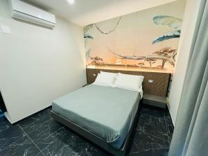 una camera da letto con un letto e un dipinto sul muro di Residenza Arena a Tropea