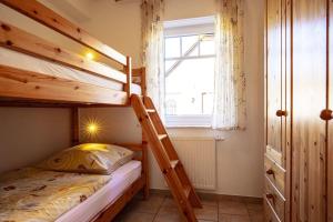 a bedroom with two bunk beds and a window at Haus Südblick, Wohnung Nr 5 in Werdum