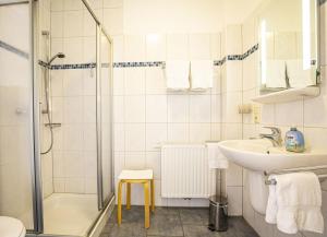 a white bathroom with a sink and a shower at Haus Südblick, Wohnung Nr 5 in Werdum