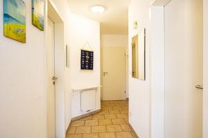 a hallway with white walls and a tile floor at Haus Südblick, Wohnung Nr 5 in Werdum
