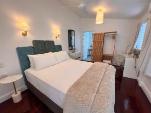 1 dormitorio con 1 cama blanca grande con detalles verdes en Floriana Boutique Hotel, en Cairns
