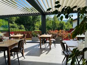 a patio with tables and chairs in a restaurant at LOGIS Hôtel St Sylvestre in Aldudes