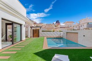 einen Hinterhof mit Pool und Gras in der Unterkunft Villa Tortuga Blanca, Ciudad Quesada, Costa Blanca in Ciudad Quesada
