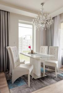 uma sala de jantar com uma mesa branca e cadeiras brancas em Modern 2 bed house near Bratislava with parking em Rovinka