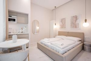 a white bedroom with a bed and a table at A13- Deluxe Apartments, Best Location, by BQA in Budapest