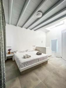 um quarto com uma cama num quarto branco em Folegandros residence/Karavostasi em Karavostasi