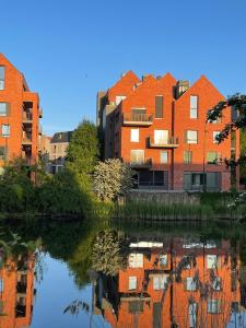 a building with a reflection in a body of water at River View Old Town in Gdańsk
