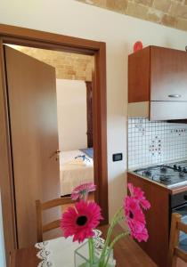 a kitchen with a table with pink flowers on it at A due passi dal mare 1 - Affitti Brevi Italia in Marina San Vito