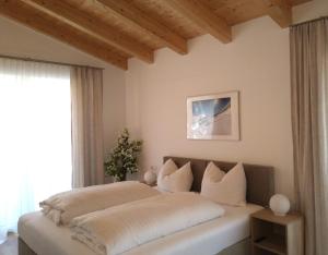 1 dormitorio con 1 cama grande con almohadas blancas en Appartements am Kirchplatz, en Fulpmes