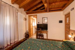 1 dormitorio con cama verde y escritorio en Maison Colombot en Aosta