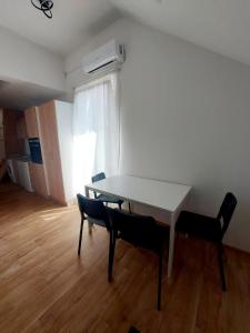 a white table and chairs in a room with a window at Magazaki Apartments Tešnjar in Valjevo