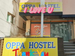 uma placa de loja em frente a uma pizzaria em OPPA Hostel Sinchon-Hongdae em Seul