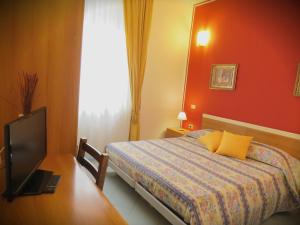 a bedroom with a bed and a television in it at Hotel Emily Fiera in Lainate