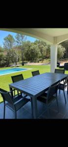 a wooden table and chairs on a patio at Villa Coco avec jardin piscine et terrain de boules de 180 m carrés in Les Arcs sur Argens