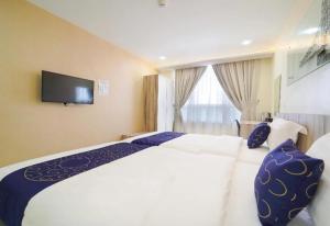 OYO 90975 Atta Hotel في بوكيت ميرتاجام: غرفة في الفندق مع سرير وتلفزيون على الحائط