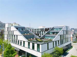 un edificio de oficinas con un diseño geométrico en la fachada en Flow and Co. Qingdao, Autograph Collection en Qingdao