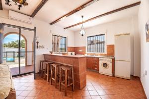 a kitchen with a bar with stools at Casa rural Montemayor in Moguer