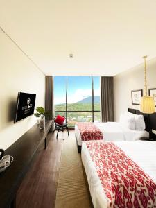 Cette chambre comprend deux lits et une grande fenêtre. dans l'établissement Suni Hotel and Convention Abepura managed by Parkside, à Tobadi